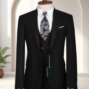 A premium classic black three-piece single-breasted suit with a double-breasted waistcoat, white shirt, and paisley tie displayed on a mannequin.