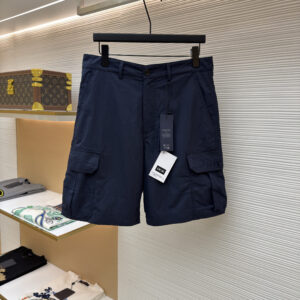 A pair of Dior Navy Cargo Shorts hanging on a black hanger, showing the front view with tonal embroidery and the back view with a leather logo patch.
