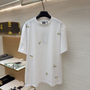A premium Dior White Daisy Embroidered T-Shirt hanging on a black hanger, showing the front view with scattered daisy motifs and a matching back view.