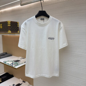 A premium Dior White T-Shirt displayed on a black hanger, showing the front view with a small logo patch and the clean back view.