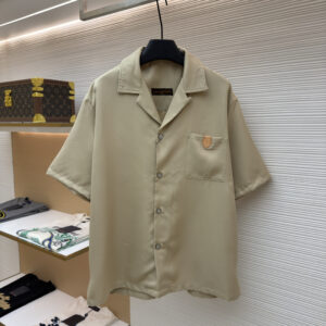 A premium Louis Vuitton Beige Short Sleeve Shirt with a camp collar and chest pocket hanging on a black hanger, showing front and back views.