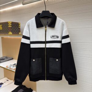 A Louis Vuitton Harrington-style jacket in black and white colour-blocking, hanging in a showroom.