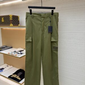 Front and back view of Louis Vuitton khaki olive green cargo trousers hanging in a luxury showroom.