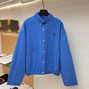 Miu Miu Blue Cotton Bomber Jacket in cornflower blue hanging on a display rack.