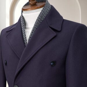 A men's navy blue double-breasted formal overcoat with matching dark buttons on a wooden mannequin.
