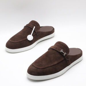 Dark brown suede slip-on mules with an apron toe and white rubber soles on a white background.