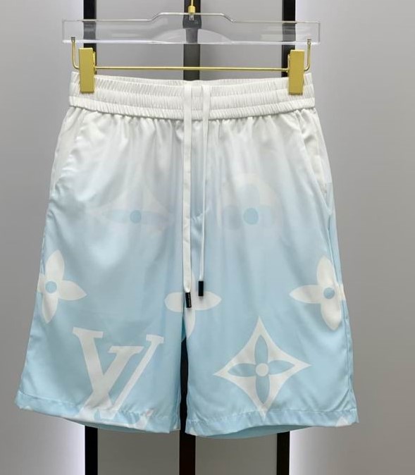 A men's matching two-piece casual set featuring a light blue and white gradient short-sleeve button-up shirt and shorts with large white monogram patterns.