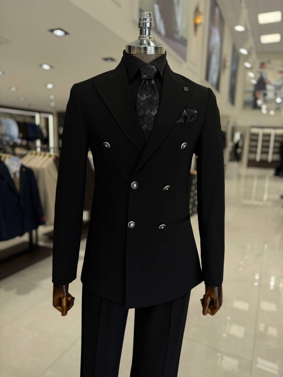 A black double breasted men's suit with peak lapels and a tapered fit, made for weddings, office wear, and formal events.