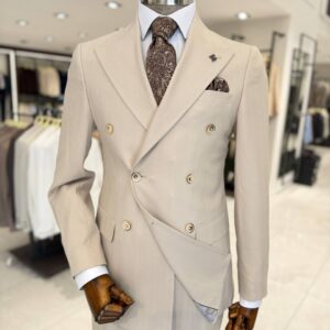 Men’s beige double-breasted suit with subtle check pattern, peak lapels and matching trousers