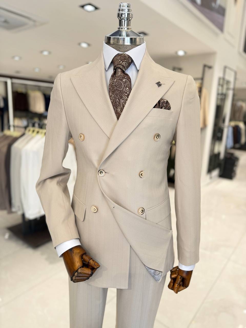 Men’s beige double-breasted suit with subtle check pattern, peak lapels and matching trousers